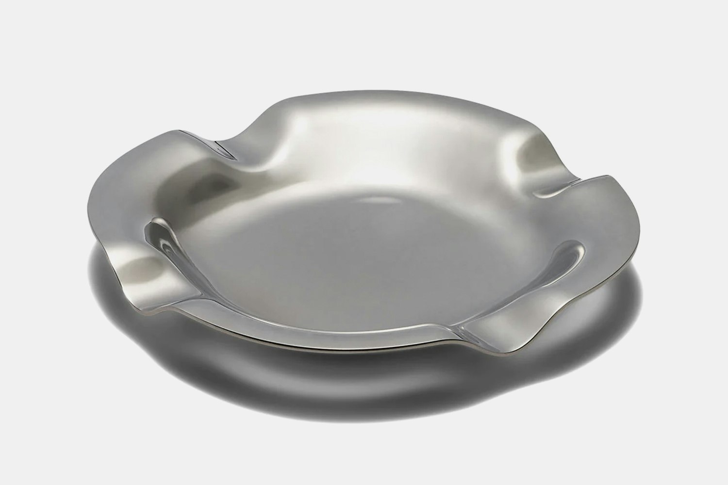a silver metal ashtray with a wavy edge
